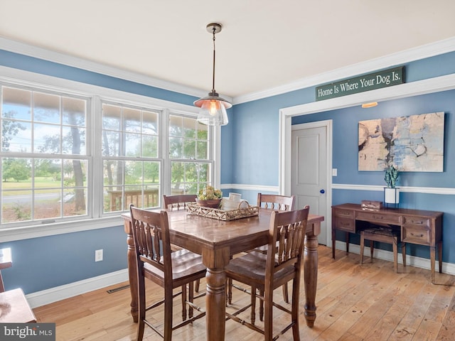 dining area featuring ornamental molding and light wood-type flooring