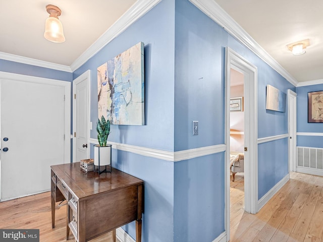 hallway featuring light wood-type flooring and crown molding