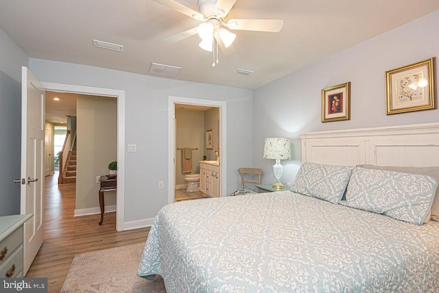 bedroom with ceiling fan, light wood-type flooring, and ensuite bathroom