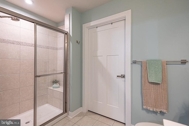 bathroom with a shower with shower door and tile patterned flooring