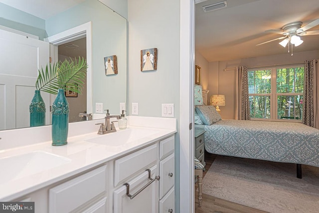 interior space with vanity, hardwood / wood-style floors, and ceiling fan