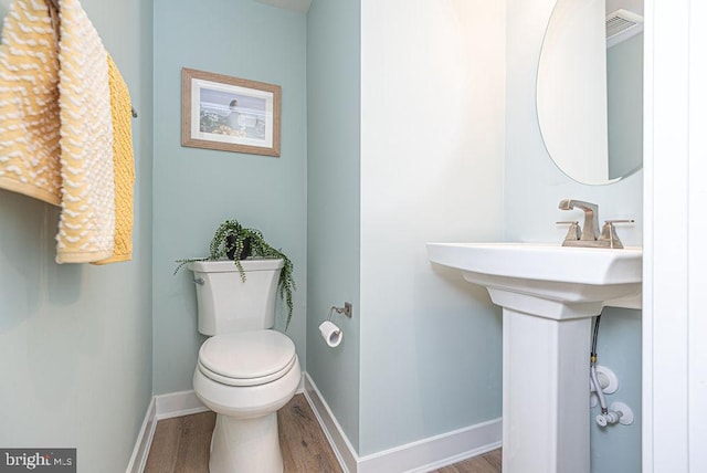 bathroom with toilet and hardwood / wood-style floors