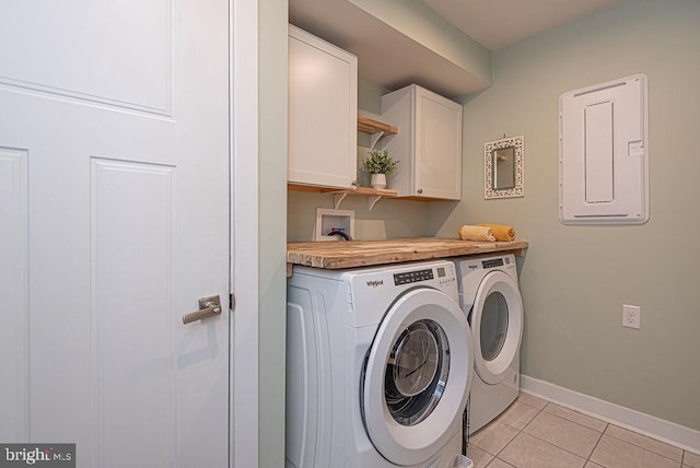 laundry room with electric panel, cabinets, washing machine and dryer, and light tile patterned flooring