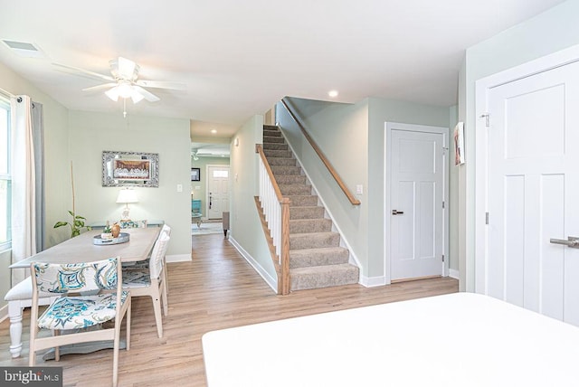 staircase with wood-type flooring and ceiling fan