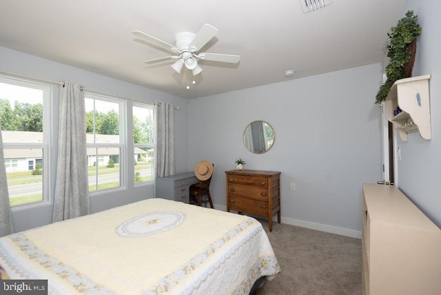 bedroom featuring light carpet, multiple windows, and ceiling fan