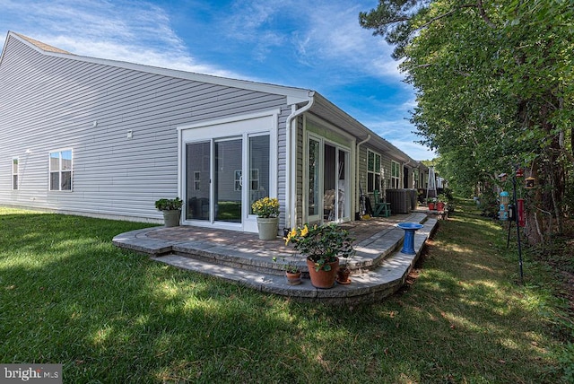 back of property with a lawn and a patio