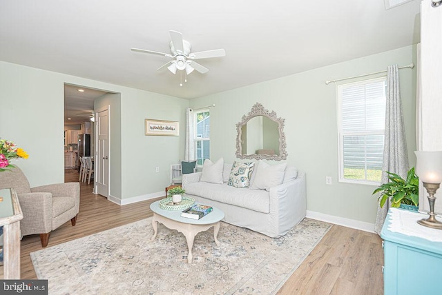 living room with light hardwood / wood-style flooring and ceiling fan