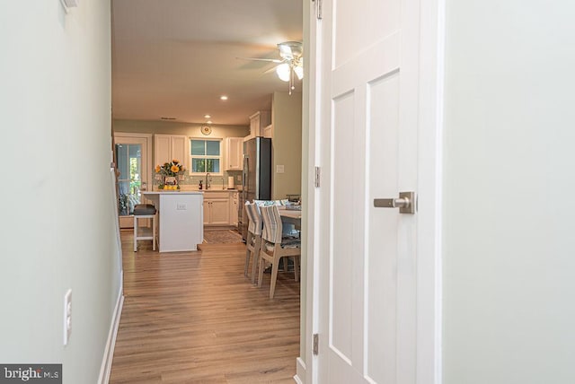 corridor with sink and light hardwood / wood-style flooring