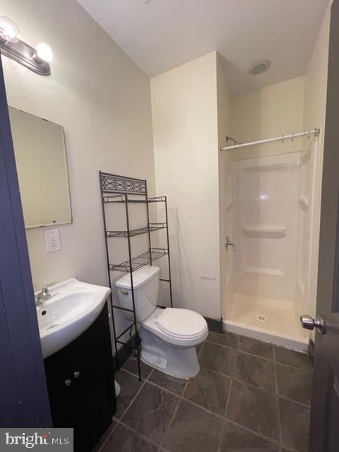 bathroom featuring vanity, toilet, and walk in shower