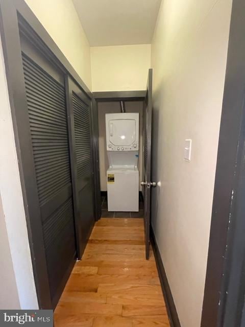 hall with light wood-type flooring and stacked washer and dryer