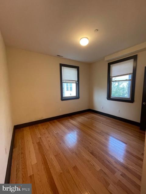 unfurnished room with wood-type flooring