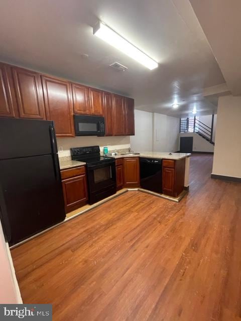 kitchen featuring black appliances and wood-type flooring