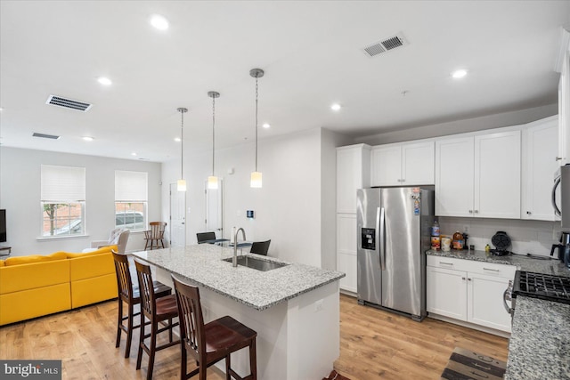 kitchen featuring sink, appliances with stainless steel finishes, light stone countertops, and light hardwood / wood-style floors