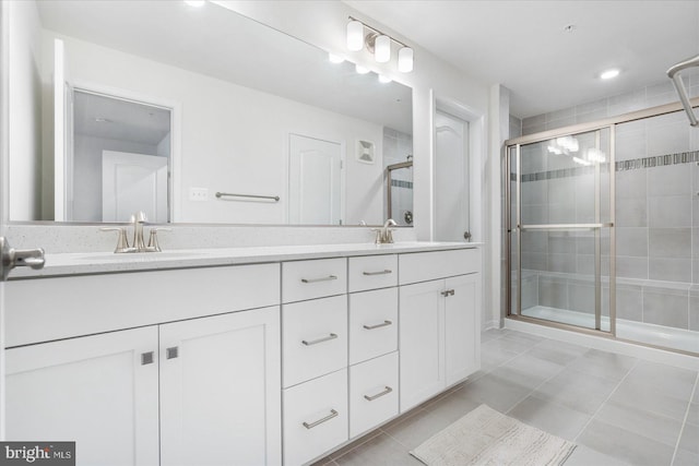 bathroom with a shower with door, tile patterned flooring, and vanity