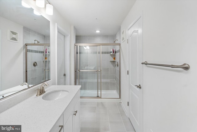 bathroom featuring tile patterned flooring, vanity, and a shower with shower door