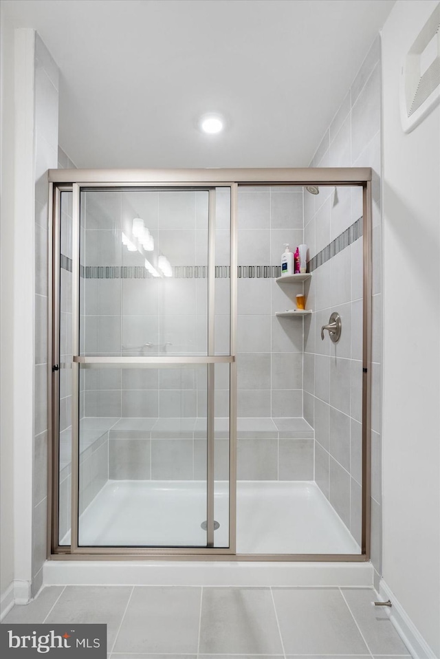 bathroom with tile patterned flooring and a shower with door