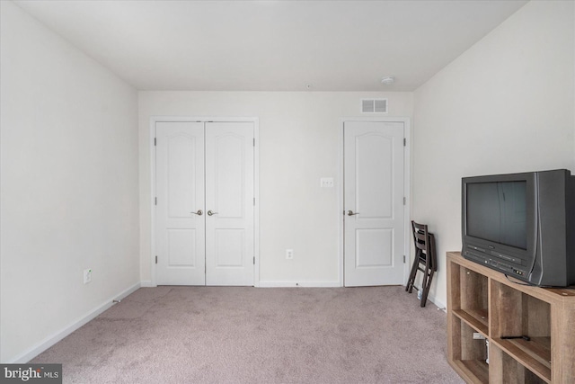 bedroom featuring light carpet and a closet