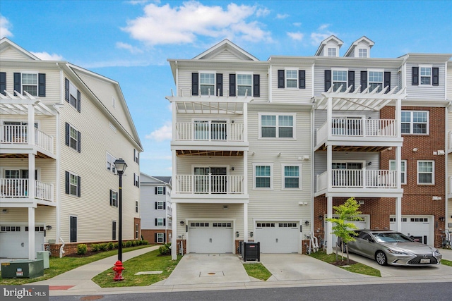 view of property with a garage, a balcony, and central AC