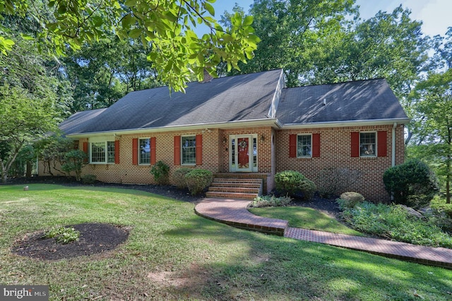 ranch-style house with a front yard and brick siding