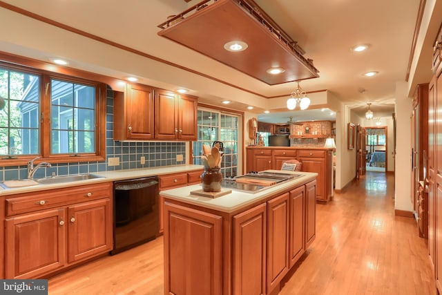 kitchen with a sink, a kitchen island, light countertops, hanging light fixtures, and dishwasher