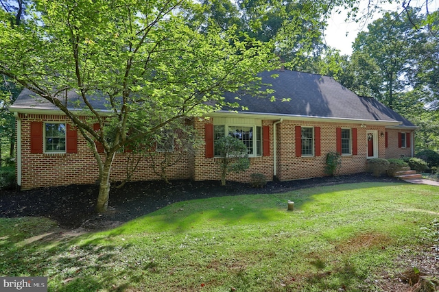 view of side of home with brick siding and a lawn