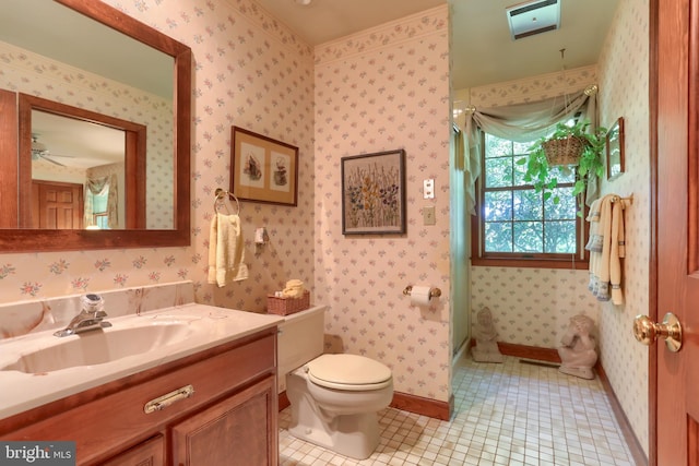 bathroom with baseboards, vanity, toilet, and wallpapered walls