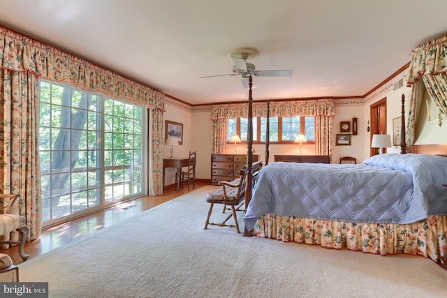 carpeted bedroom featuring ceiling fan, multiple windows, and crown molding