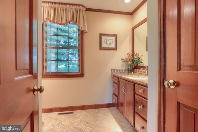 bathroom featuring visible vents, crown molding, vanity, and baseboards