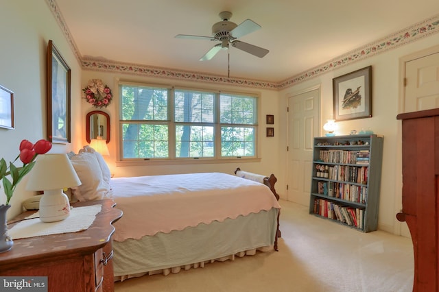 bedroom featuring a ceiling fan and light colored carpet