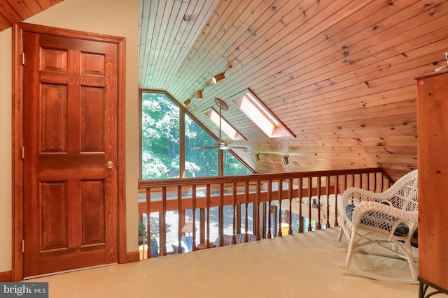 interior space with vaulted ceiling with skylight, wood ceiling, and ceiling fan