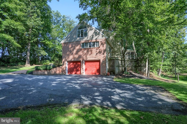 view of property exterior with aphalt driveway, brick siding, and a garage