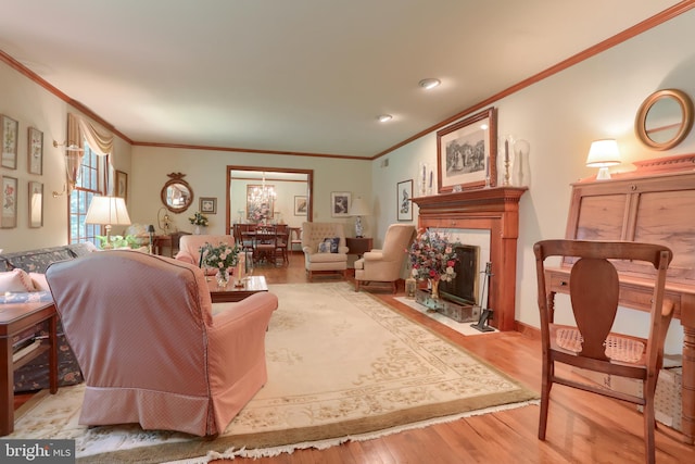 living area featuring a fireplace with flush hearth, light wood-style flooring, and crown molding