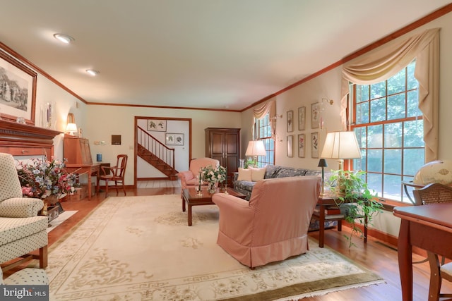 living room featuring stairs, ornamental molding, wood finished floors, and baseboards