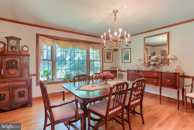 dining space featuring light wood finished floors, baseboards, a chandelier, and ornamental molding