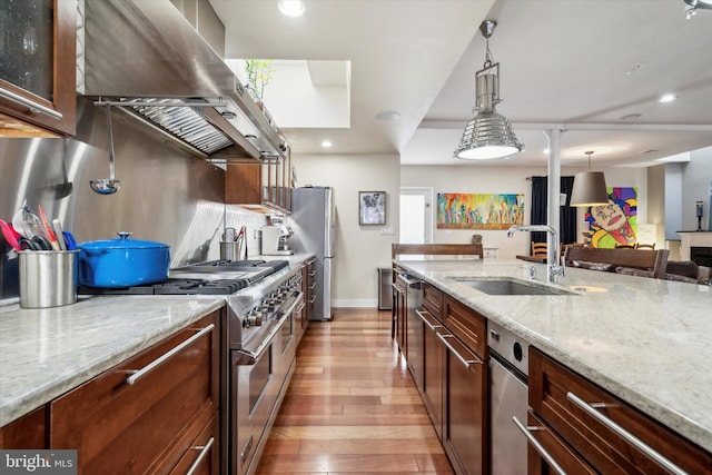 kitchen featuring dark hardwood / wood-style floors, brick wall, tasteful backsplash, double oven range, and sink