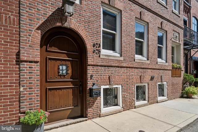 doorway to property with brick siding