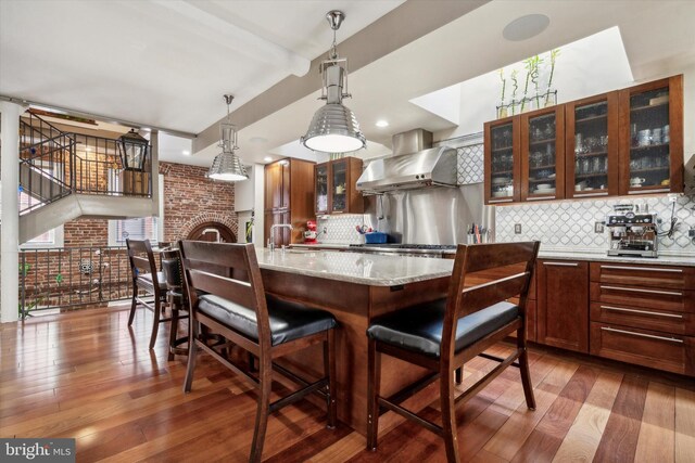 dining space with a fireplace, beamed ceiling, and wood-type flooring