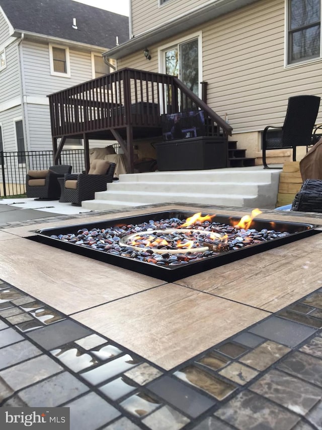 wooden terrace with a patio area and a fire pit