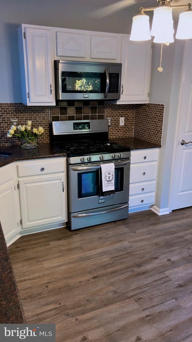 kitchen with white cabinetry, appliances with stainless steel finishes, dark wood-type flooring, and decorative backsplash