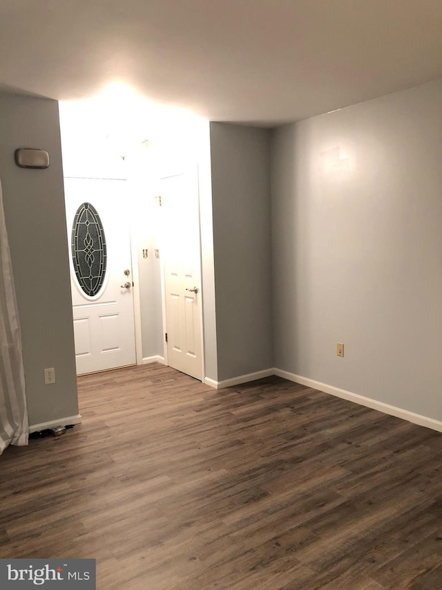 foyer featuring dark wood finished floors and baseboards