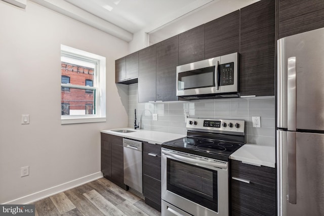 kitchen featuring sink, light wood-type flooring, dark brown cabinets, and stainless steel appliances