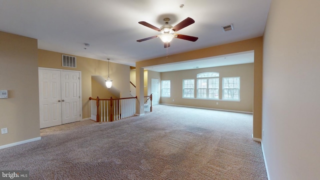 carpeted spare room featuring ceiling fan