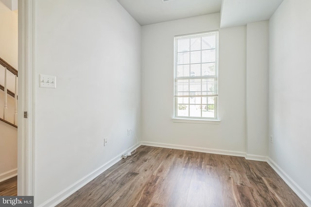 unfurnished room with baseboards and wood finished floors