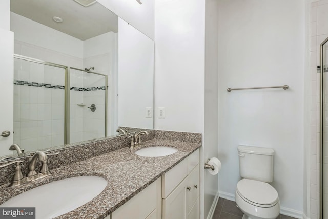 bathroom with a sink, a shower stall, toilet, and double vanity