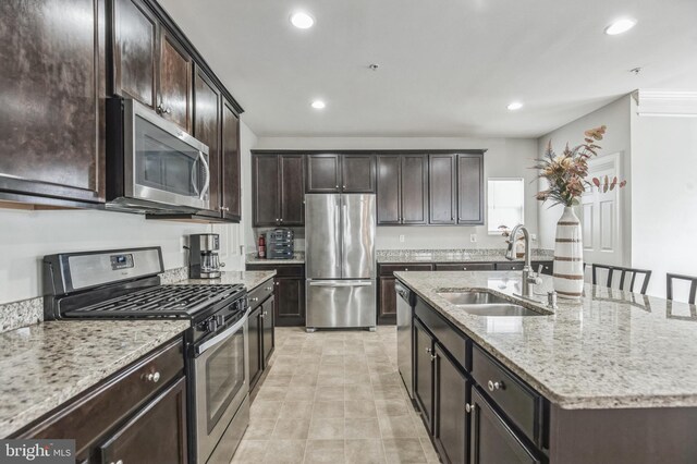 kitchen with a wealth of natural light, a kitchen island with sink, a breakfast bar, and stainless steel appliances