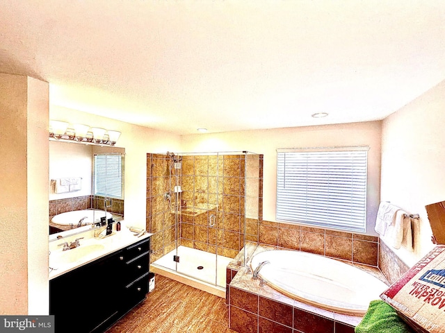 bathroom with vanity and shower with separate bathtub