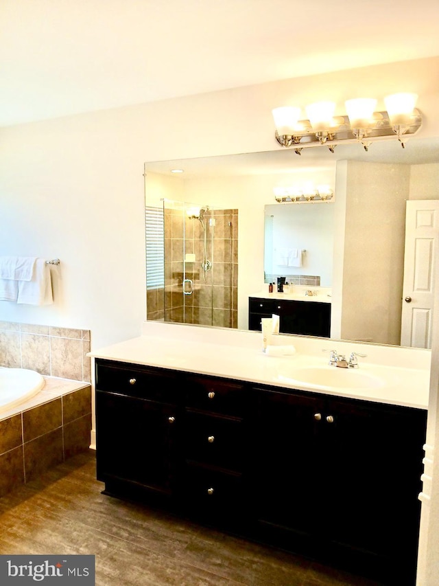 bathroom featuring vanity, plus walk in shower, and hardwood / wood-style flooring