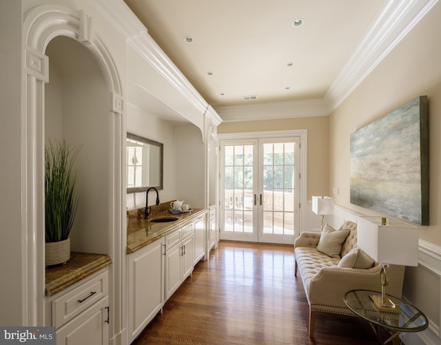 living area with arched walkways, french doors, crown molding, visible vents, and dark wood-type flooring