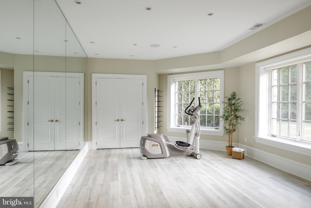 exercise room with visible vents, baseboards, and wood finished floors