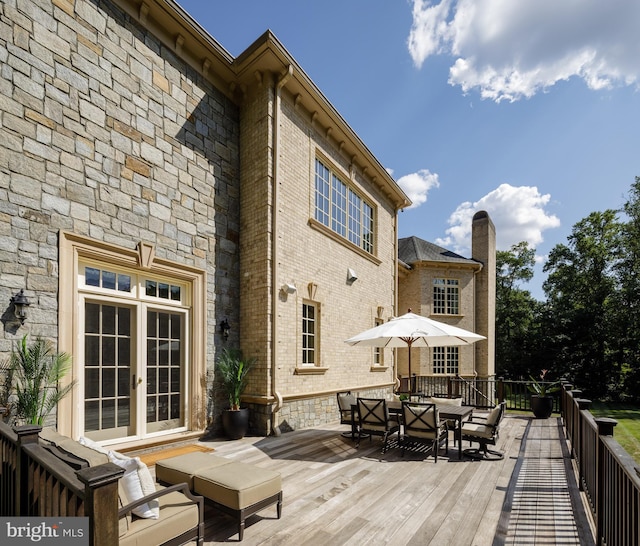 wooden deck featuring french doors and outdoor dining space